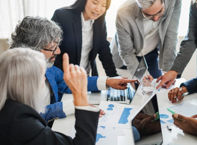 Multigenerational business people working inside corporate office - Finance strategy concept - Focus on senior man glasses